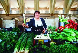 Marktfrau mit saftigem Gemüse
