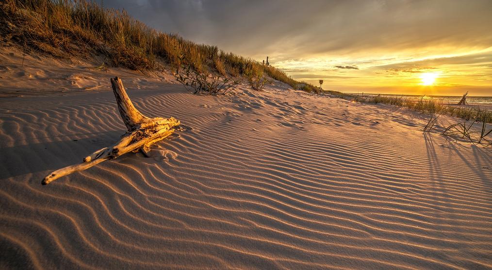 Von der untergehenden Sonne beschienene Dünen im Slowinski Nationalpark