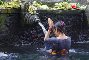 Einheimische Frau an der Quelle in Pura Tirta Empul