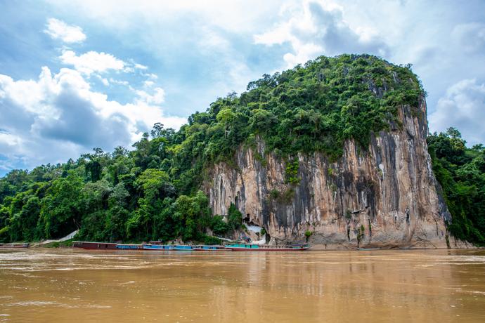 Zu sehen ist der Felsvorsprung der Pak Ou-Höhlen. Diese liegen malerisch am Mekong-Fluss und sind von steilen Kalksteinfelsen umgeben. 