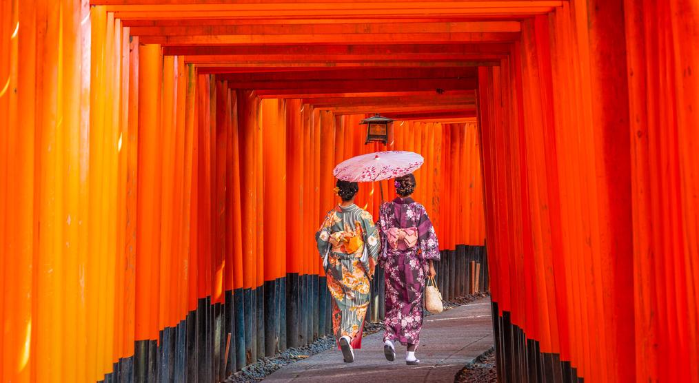 Frauen in Kimonos zwischen den Torii Toren