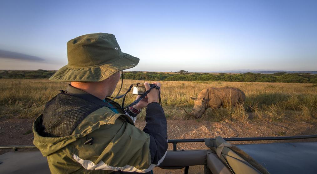 Ein Tourist fotografiert ein Nashorn