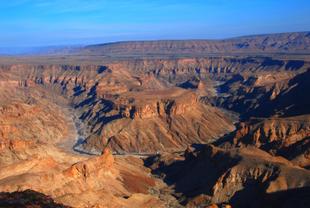 Zu sehen ist der Fish River Canyon in Namibia, eine beeindruckende Schlucht, die sich tief in die trockene Wüstenlandschaft schneidet. 