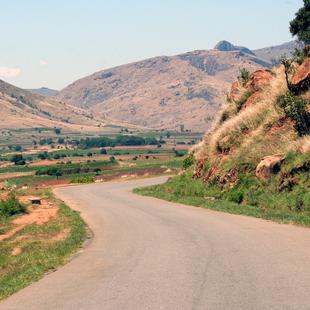 Eine Straße führt durch bergige Landschaft.