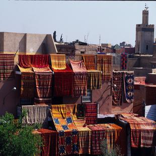 Marokko: Marrakesch, bunte Teppiche auf Hausdächern