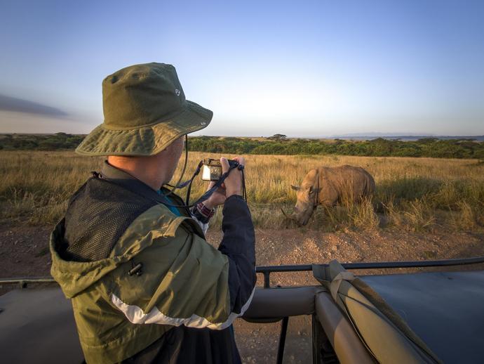 Ein Tourist fotografiert ein Nashorn