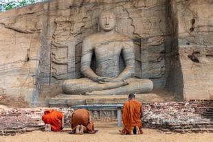 betende Mönche vor einer buddhistischen Statue in Polonnaruwa