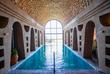 Wellnessanlage mit Pool, umgeben von hohen Steinwänden und einer beruhigenden Atmosphäre, perfekt zum Entspannen.