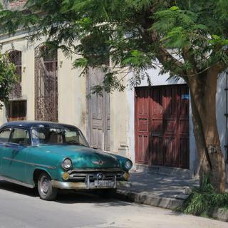 Typischer Oldtimer vor einer Häuserzeile in Havanna