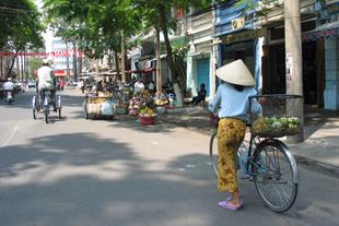 Frau mit einem Fahrrad in Saigon 