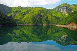 Spiegelung der Berge im Koman Stausee