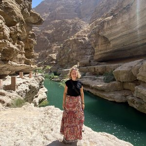 Mitarbeiterin vor der Oasenlandschaft "Wadi Bani Khalid" in Oman
