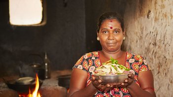 Frau in traditioneller Küche mit Essen