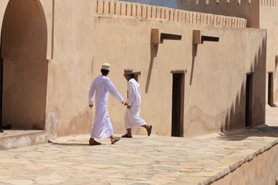 Münner vor Stadtmauer, Oman