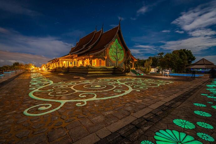  Zu sehen ist das Wat Sirindhorn Wararam in Ubon Ratchathani bei Nacht, wenn der Tempel in einem sanften Licht erstrahlt.