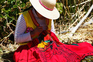 Traditionell gekleidete Frau bei Handarbeiten auf den Urosinseln