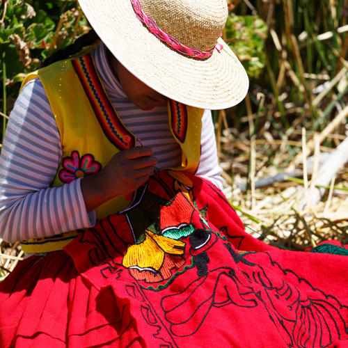 Traditionell gekleidete Frau bei Handarbeiten auf den Urosinseln