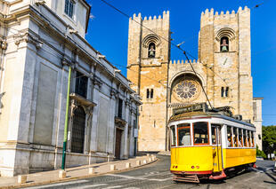 Typisch gelbe Tram vor der Kathedrale von Lissabon