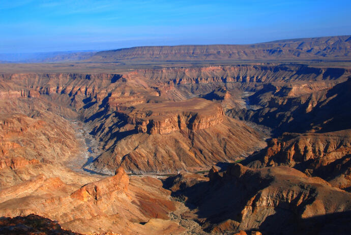 Zu sehen ist der Fish River Canyon in Namibia, eine beeindruckende Schlucht, die sich tief in die trockene Wüstenlandschaft schneidet. 