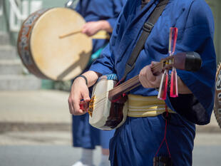 Ein Mann spielt das traditionelle Instrument Shamisen 