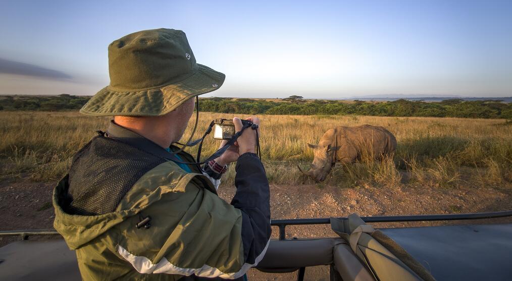 Ein Tourist fotografiert ein Nashorn