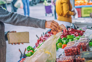 Frau bezahlt für ihren Einkauf auf dem Markt