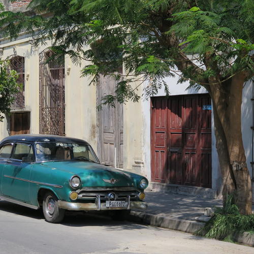 Typischer Oldtimer vor einer Häuserzeile in Havanna