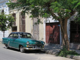 Typischer Oldtimer vor einer Häuserzeile in Havanna
