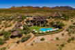 Zu sehen ist die GocheGanas Lodge von oben, eingebettet in eine wüstenartige Landschaft, mit einem glitzernden Pool, der zur Erholung einlädt.