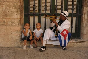 Kubanischer Straßenmusiker mit begeisterten Zuhörern