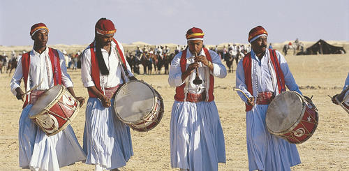 Tanzende Maenner in traditioneller Kleidung 