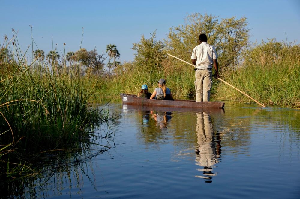 Touristen in einem Mokoro Boot