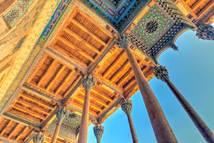  Zu sehen ist der Bolo Haouz-Komplex in Buchara aus der unteren Perspektive, die die imposante Fassade der Moschee und die kunstvollen Holzsäulen in voller Pracht zeigt.