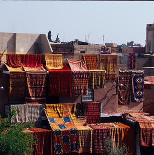 Marokko: Marrakesch, bunte Teppiche auf Hausdächern