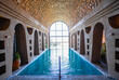 Wellnessanlage mit Pool, umgeben von hohen Steinwänden und einer beruhigenden Atmosphäre, perfekt zum Entspannen.