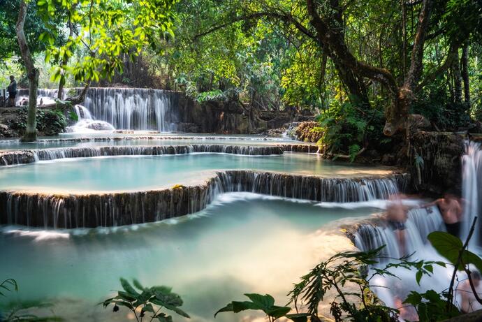  Zu sehen ist der Kuang Si Wasserfall in Luang Prabang, dessen smaragdgrünes Wasser in mehreren Stufen herabstürzt. 
