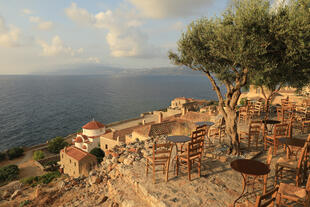 Olivenbaum mit Tisch und Stühlen in malerischen Monemvasia