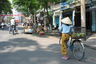 Frau mit einem Fahrrad in Saigon 