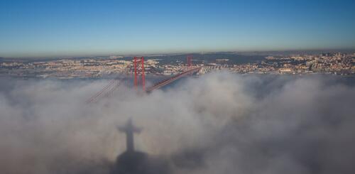 Cristo Rei-Schatten auf Wolken in Lissabon