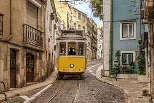 Gelbe Lissabonner Straßenbahn in enger Gasse