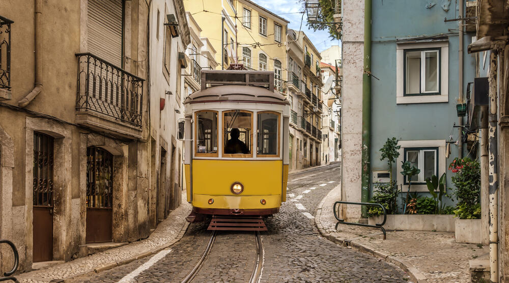 Gelbe Lissabonner Straßenbahn in enger Gasse