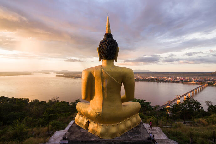 Zu sehen ist der Goldene Buddha am Phu Salao Tempel, der hoch über der Umgebung thront. Von hier aus hat man einen beeindruckenden Blick auf den Mekong-Fluss.
