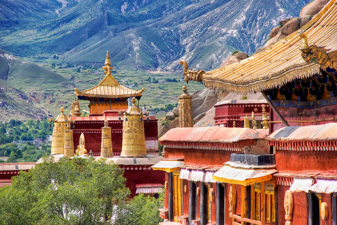 Sera-Kloster nahe Lhasa in Tibet: Traditioneller tibetischer Tempel mit kunstvoller Architektur, umgeben von Bergen und grünen Landschaften.