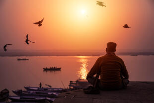 Mann beim meditieren am Ufer des Ganges 